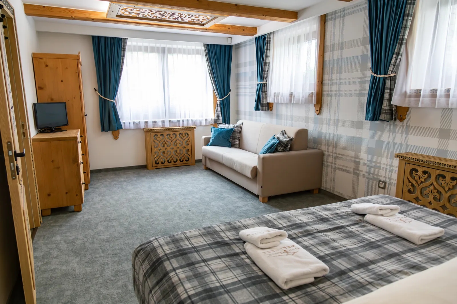 Spálňa apartmánu 21B s kockovaným prehozom