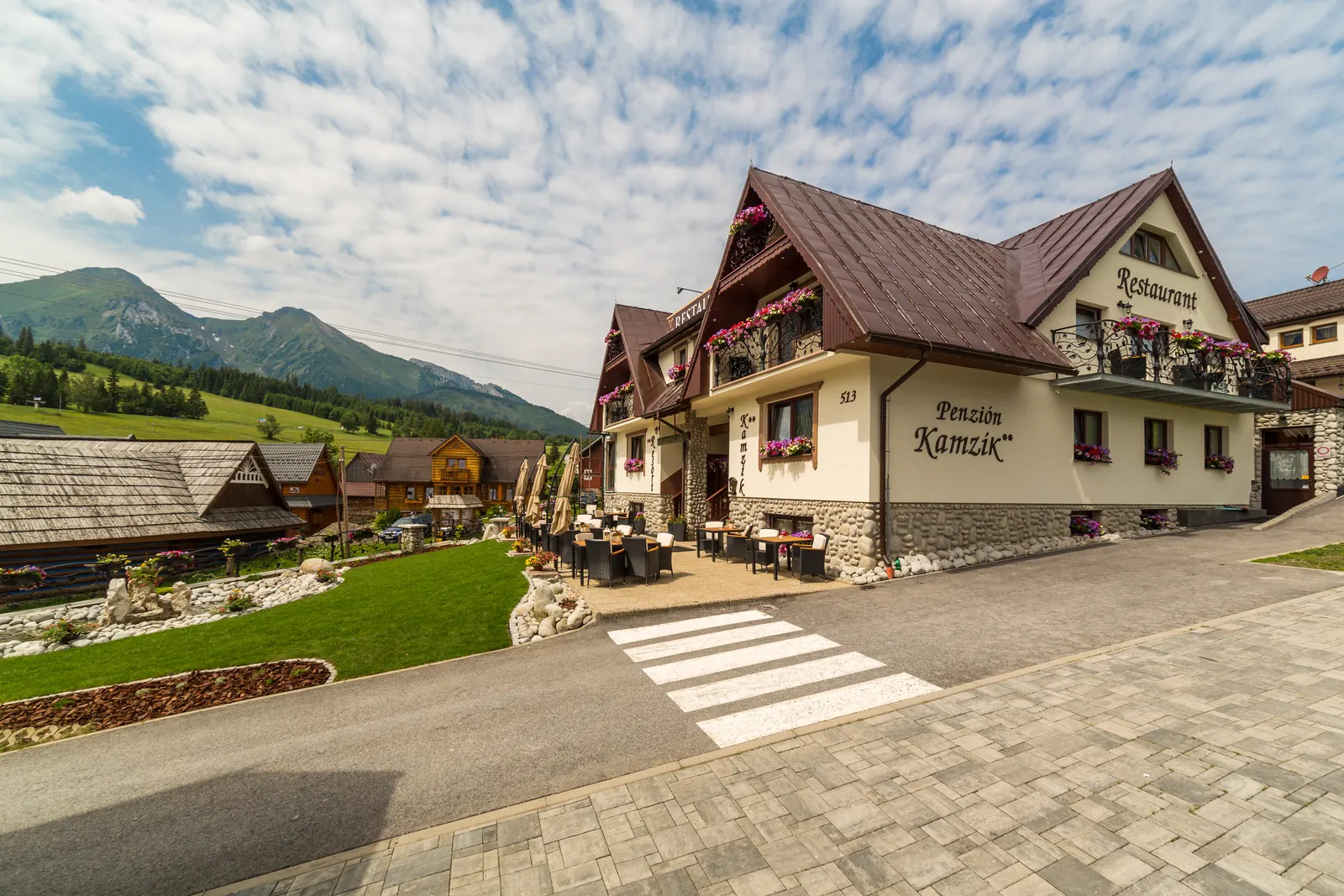 Penzión Kamzík od hlavnej cesty, za ním Belianske Tatry