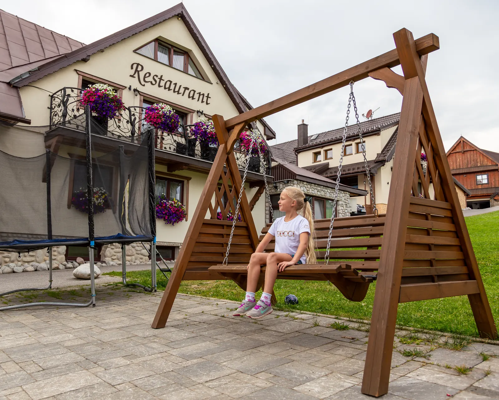 Wooden swing and trampoline in front of the restaurant