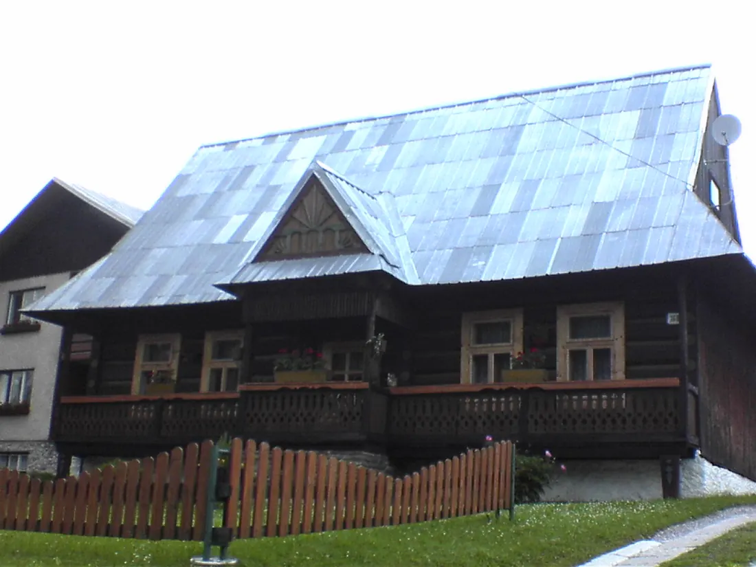 Tradičná ždiarska drevenica s vyrezávaným štítom a plotom